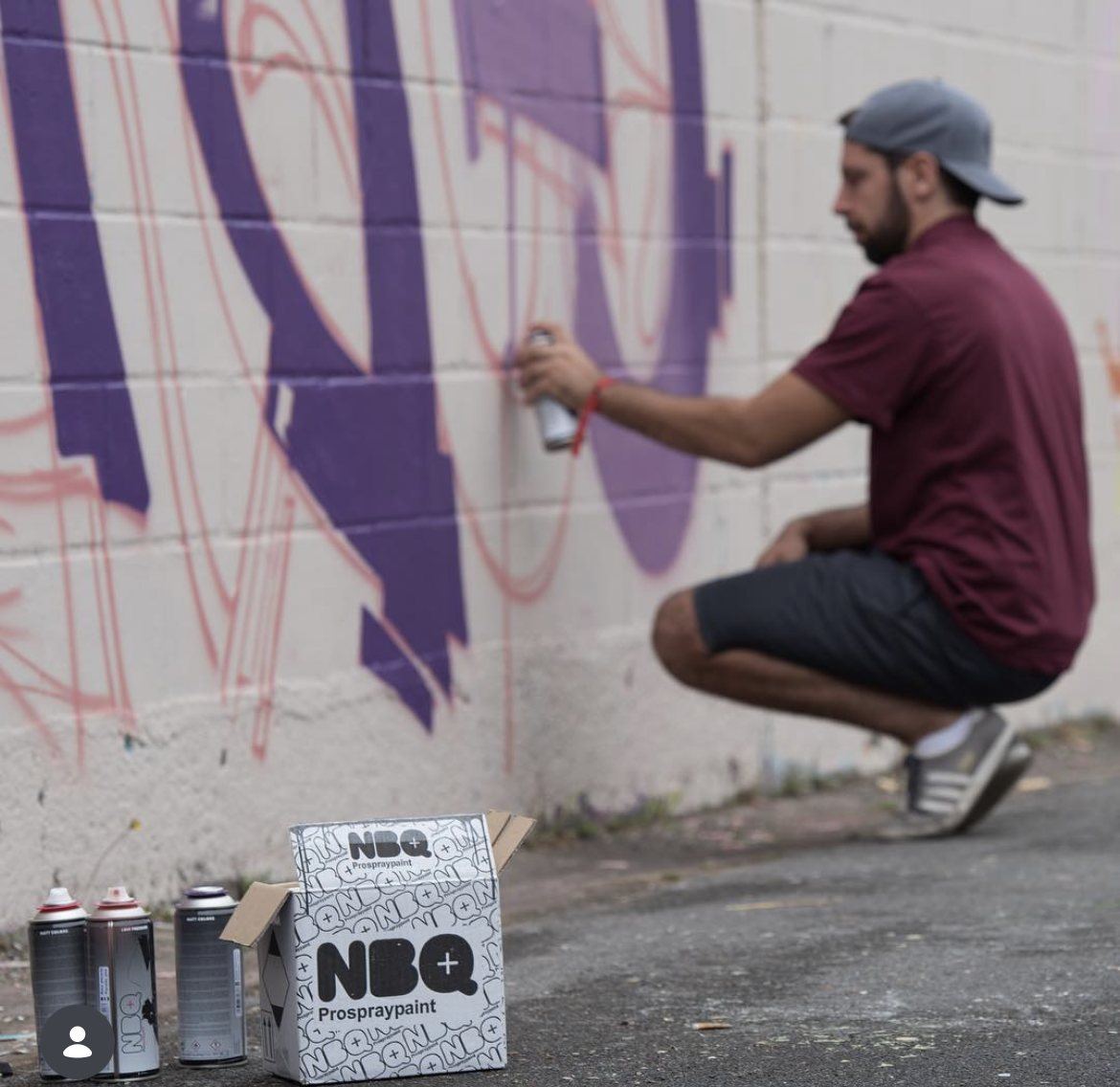Un graffeur accroupi devant son lettrage